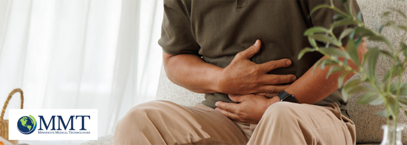 Man sitting down and holding hands around stomach to indicate stomach cramps from constipation