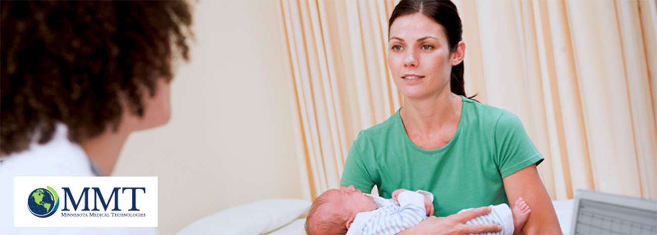 Mom holding baby while speaking to doctor in exam room