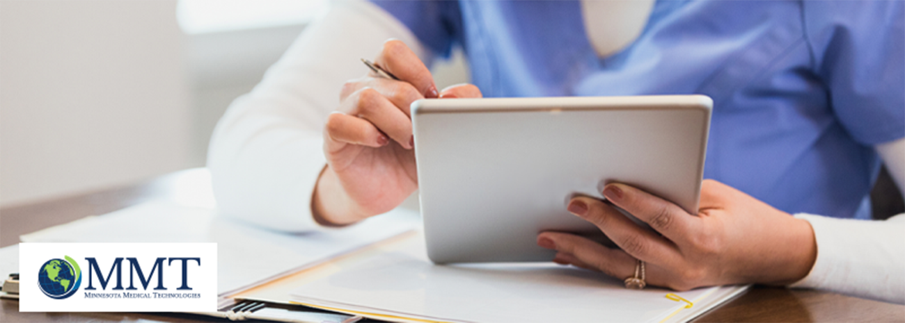 Image shows clinician using tablet at a table with other documents