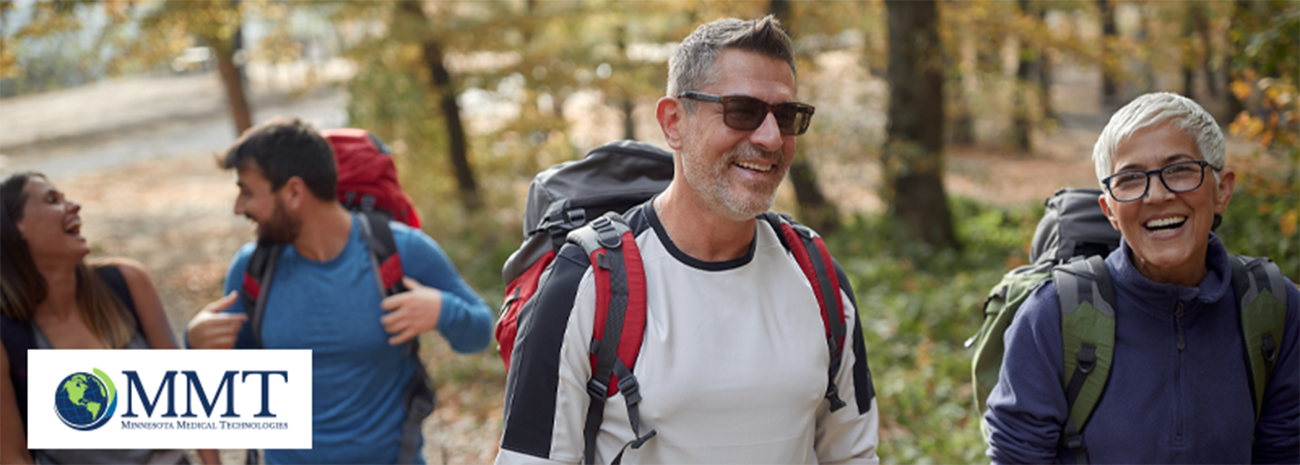 Older couple out hiking in the woods with younger couple behind them