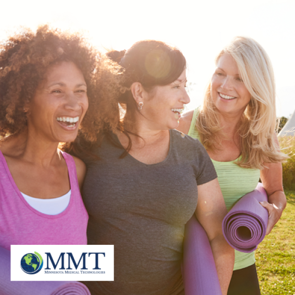 Group of smiling middle aged women outside with yoga mats being active
